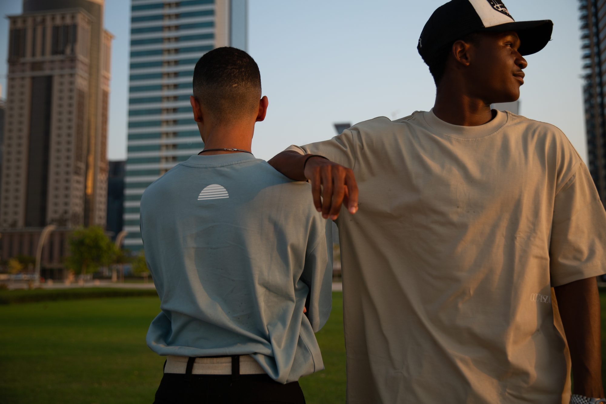 Two friends in haze blue and sand tees