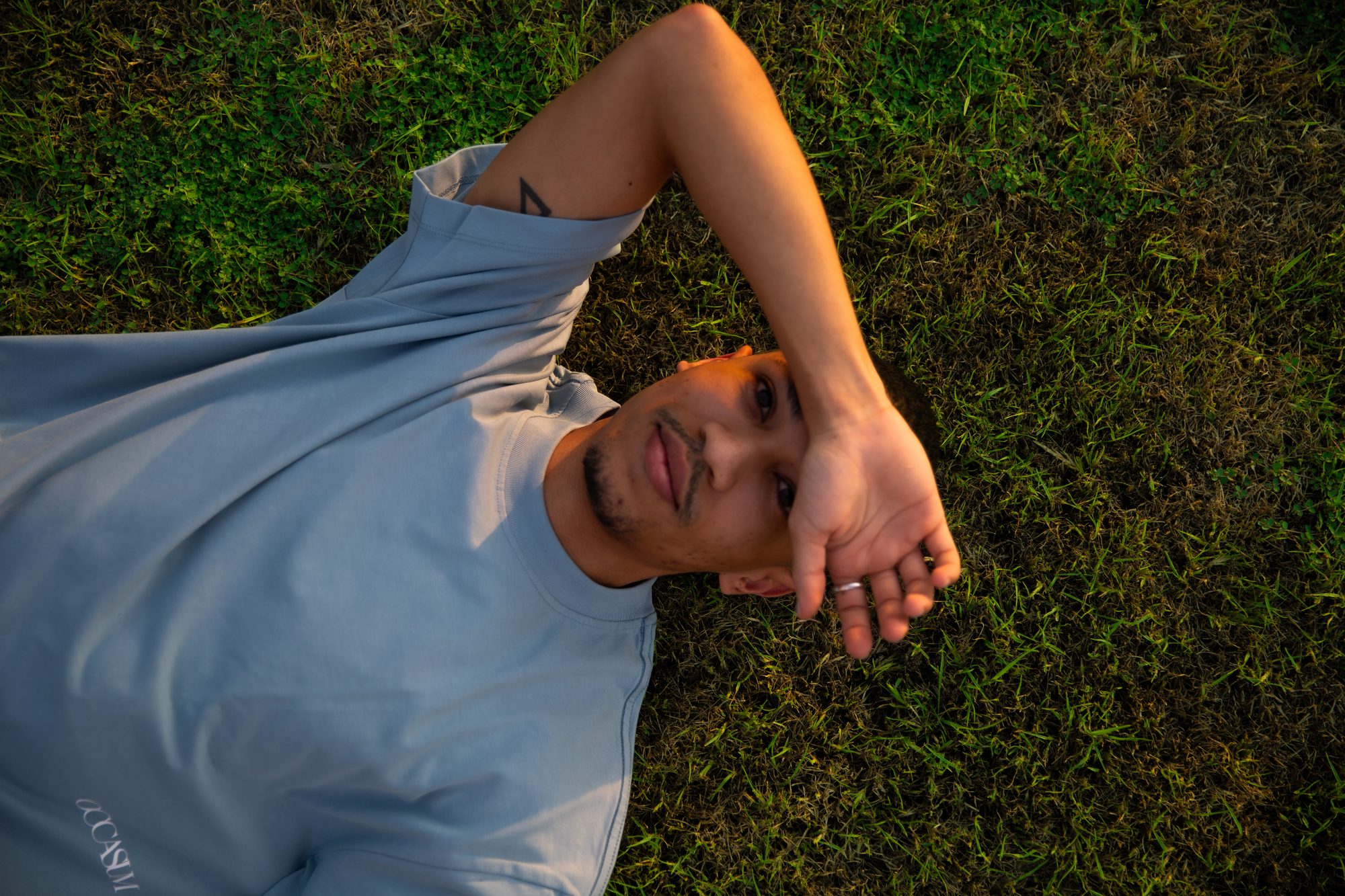Model lying on grass at golden hour